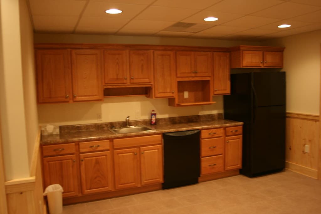 The kitchenette straight on, one long run of cabinets and counter with a sink at the middle