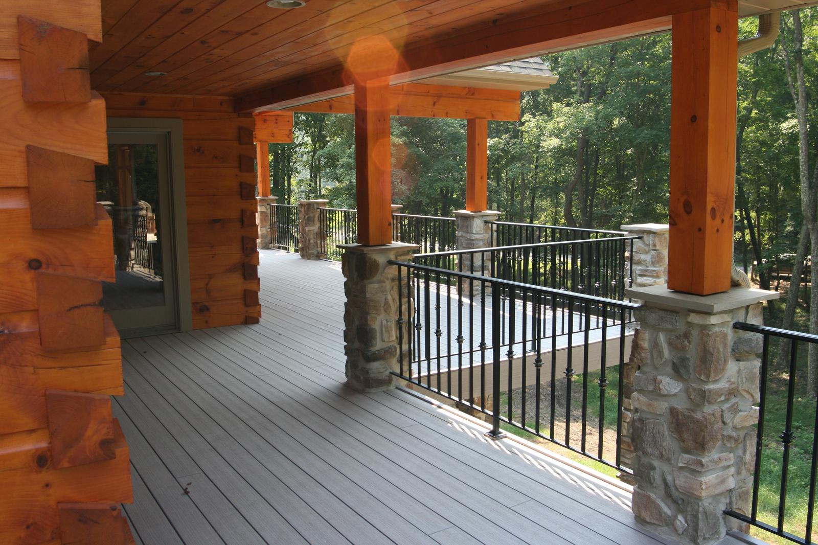The porch from the far end, log wall on one side and a run of stone piers on the other