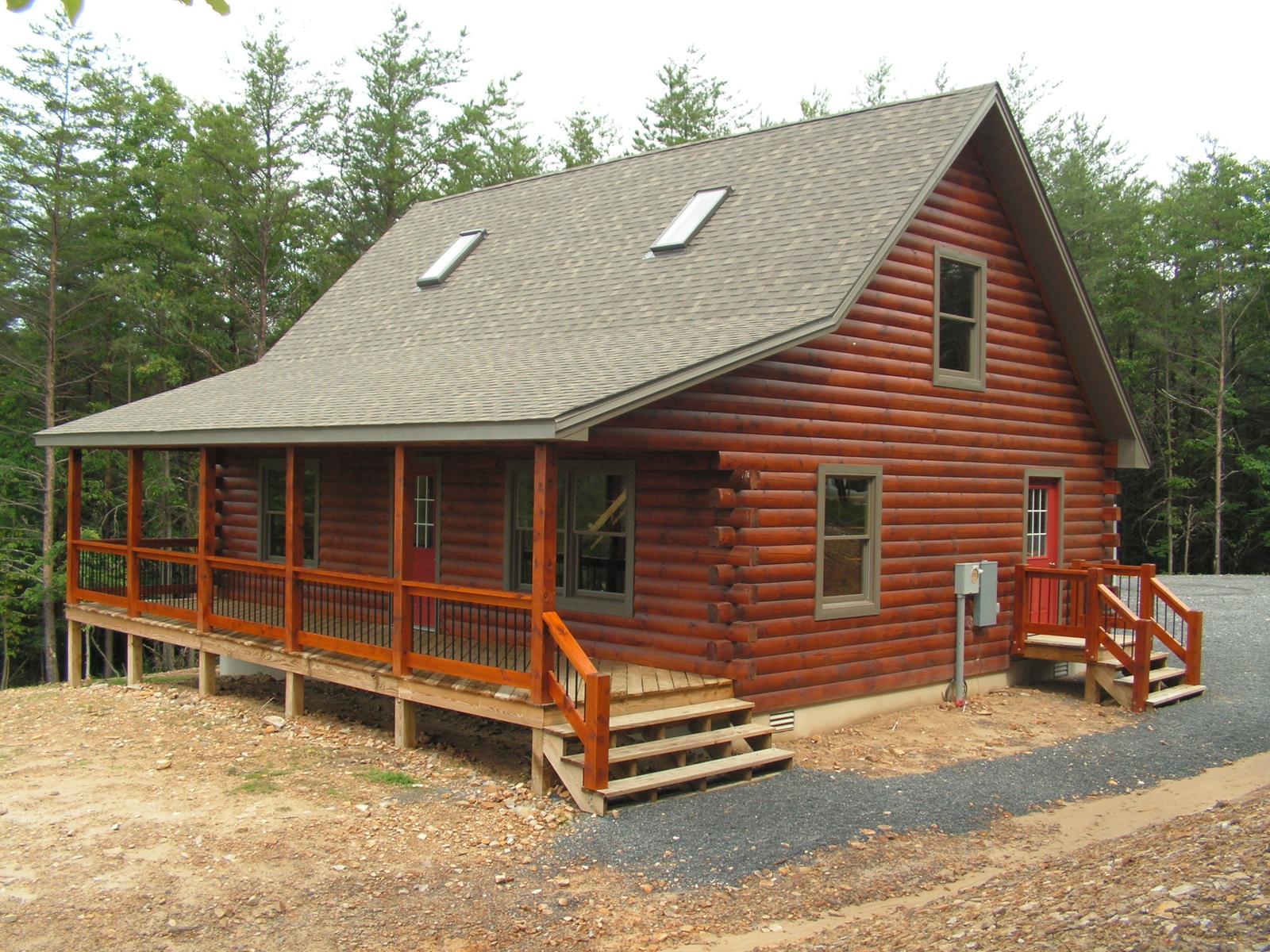 The home from the drive, porch posts and rail running the width of it under a low roof