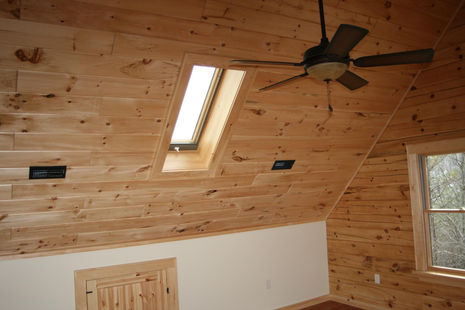 The loft ceiling and skylight, fan and board slopes meeting at the ridge