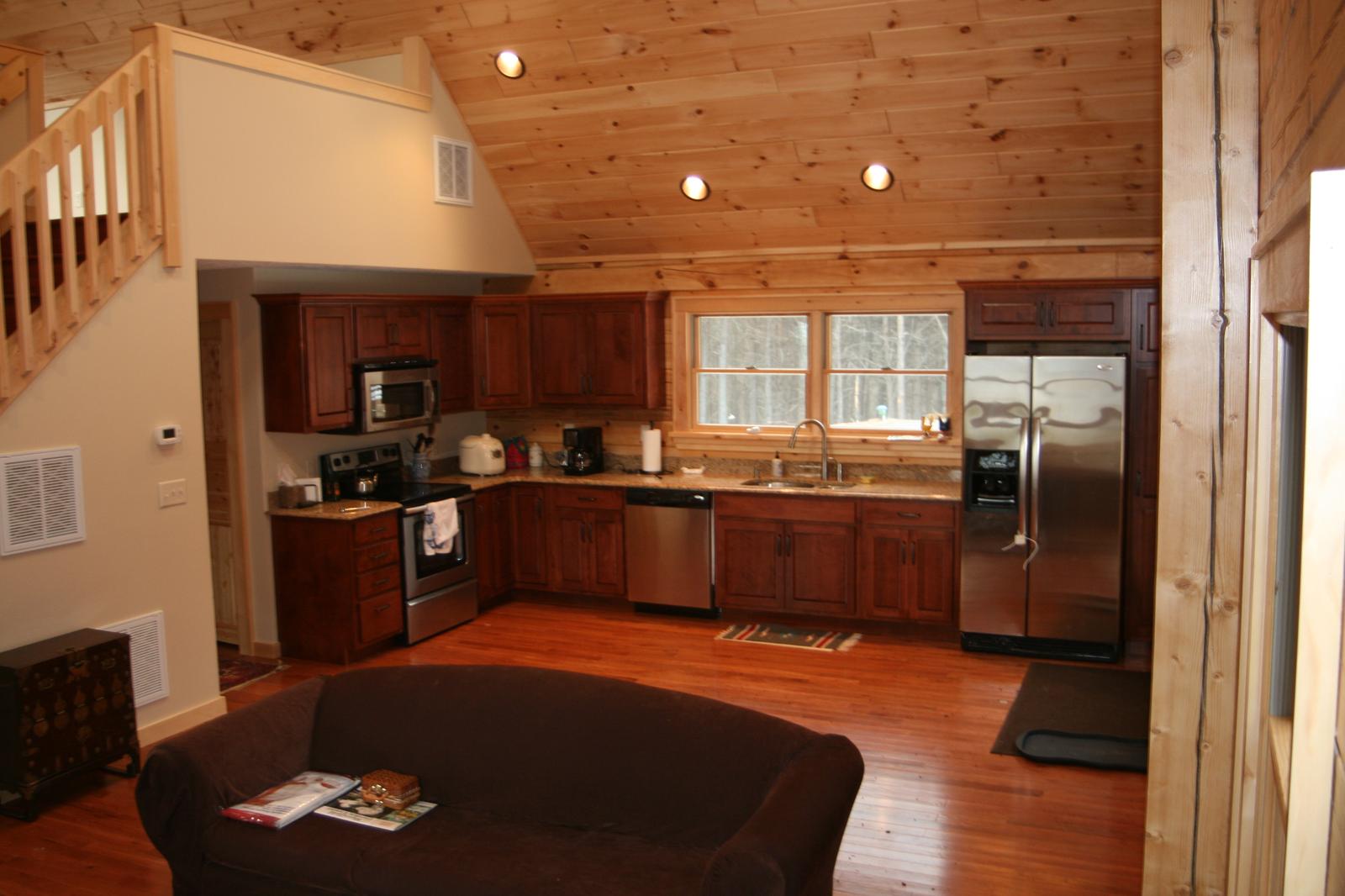 The kitchen and seating area together, loft rail above and a window over the sink