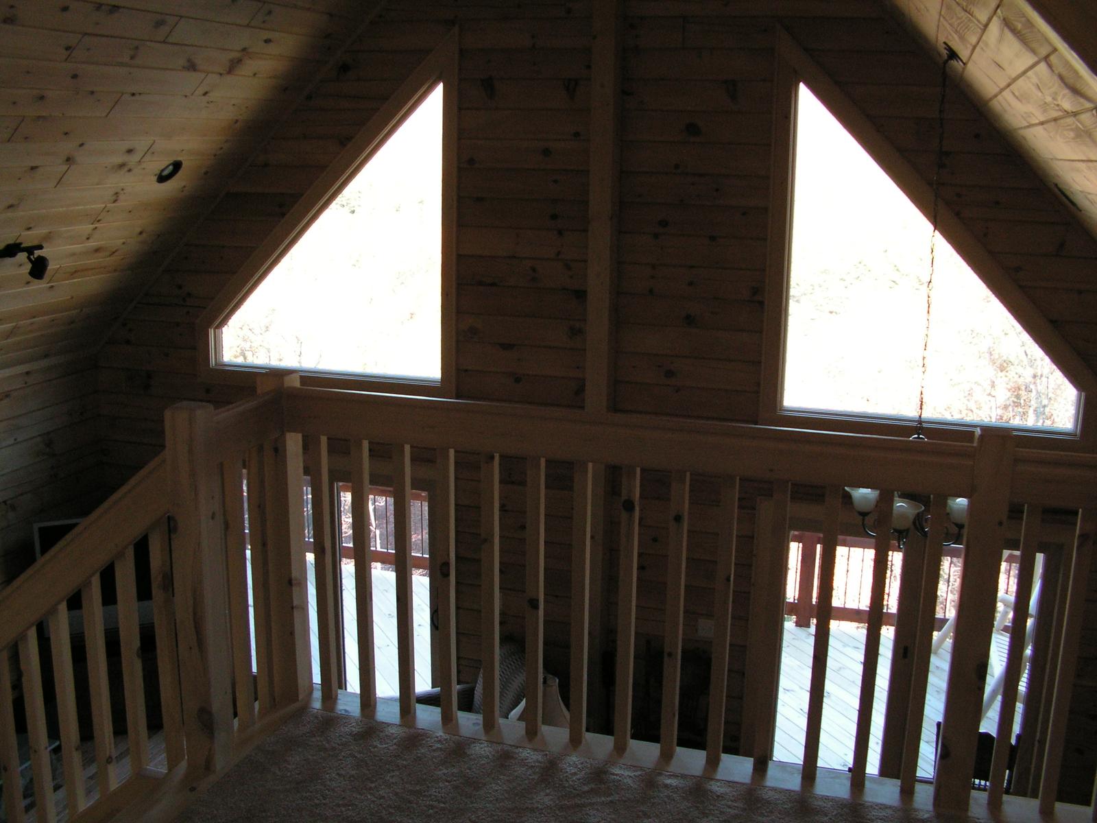 A loft under the roof slope, its rail against two triangular gable windows