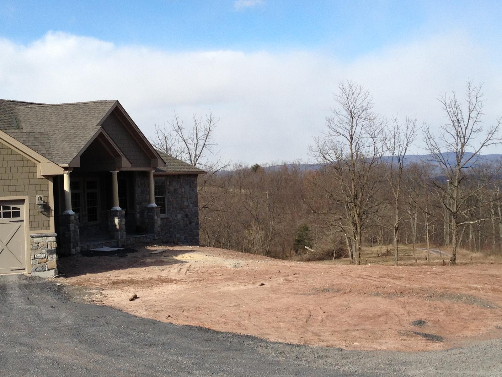 The entry and garage from the turning circle, gravel drive laid and bare trees around