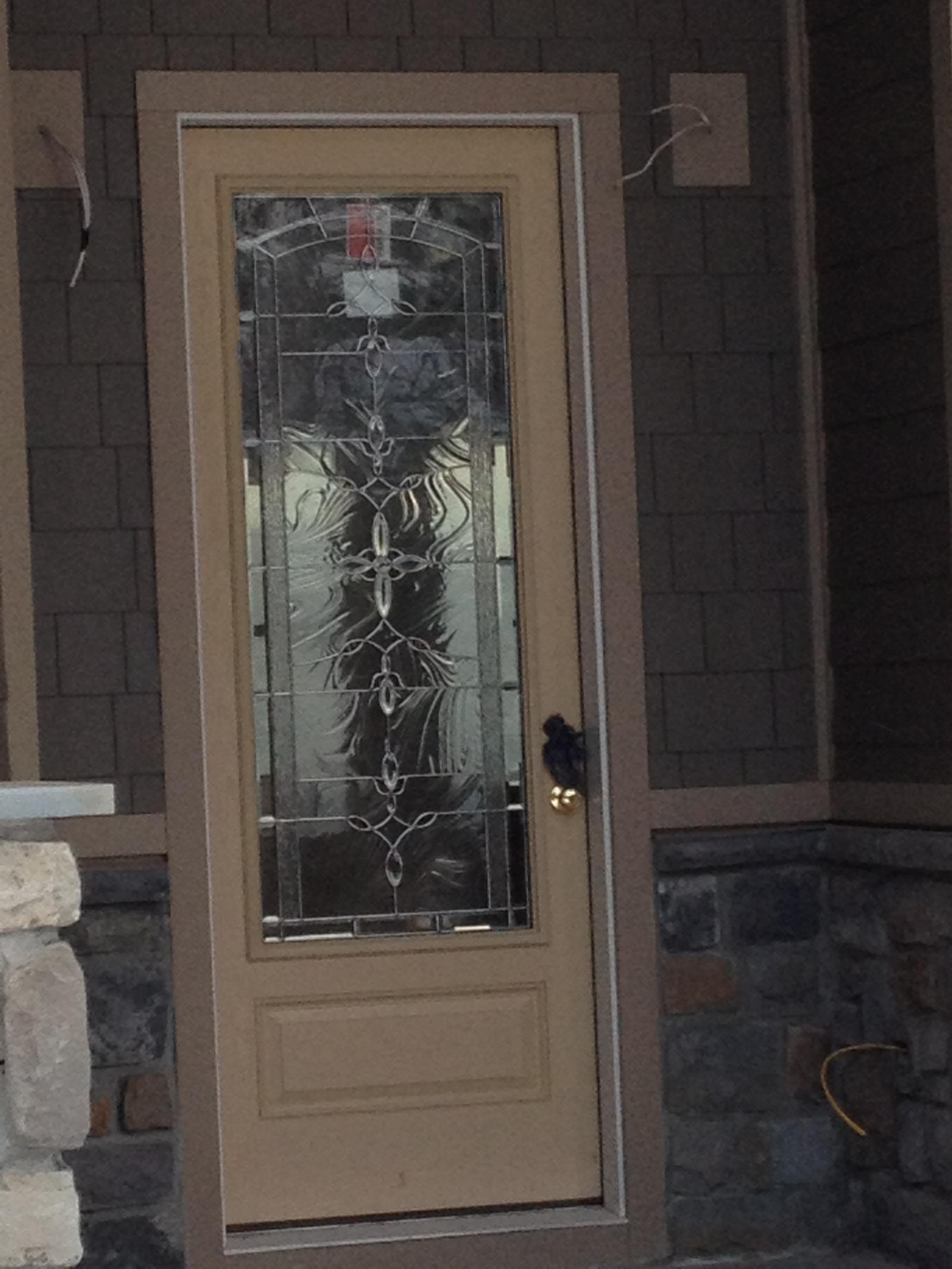 A paneled front door with a leaded glass light, still carrying its maker's sticker