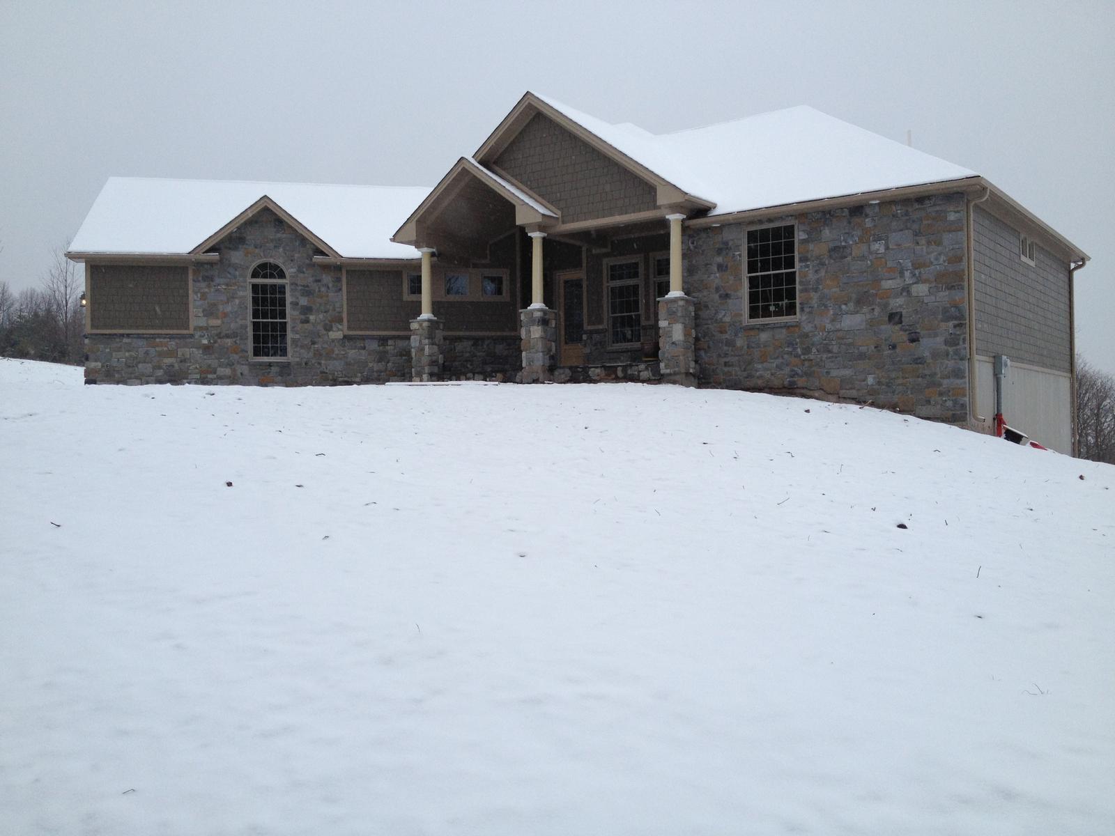 The house on its rise in snow, the ground falling away unbroken in front