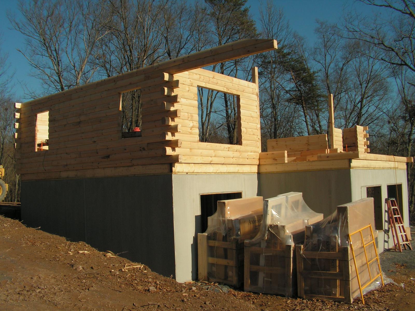 The walls up to second-floor height with a window opening framed in the gable, materials stacked below
