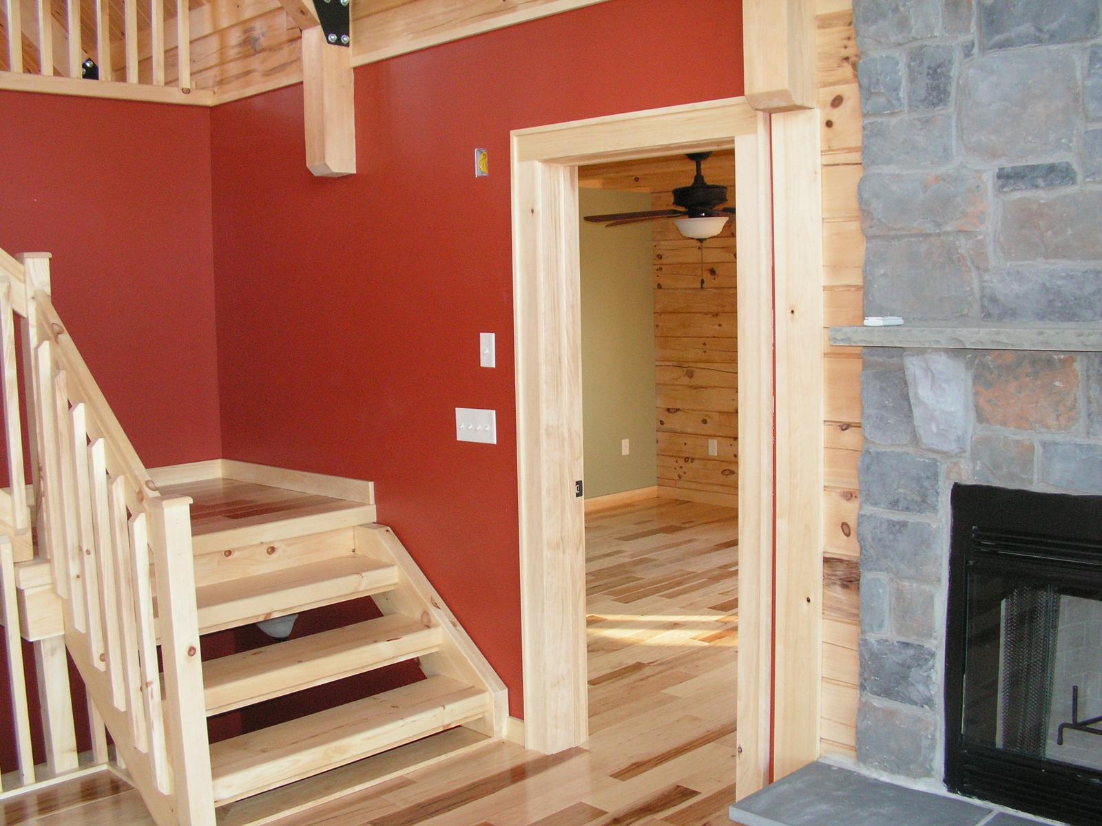 A stair landing between red walls, the stone chimney and a firebox visible through the opening