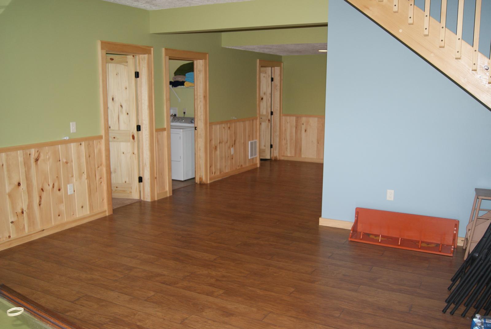 The lower level toward two open doorways, a laundry visible through one of them