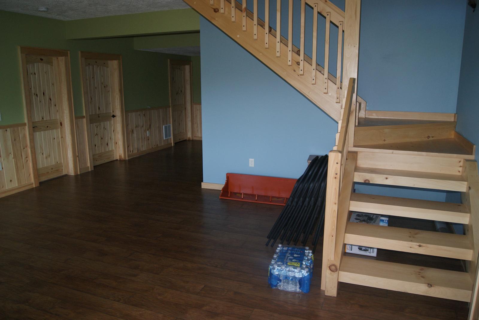 The same room from the stair, doors along the far wall and bare floor between