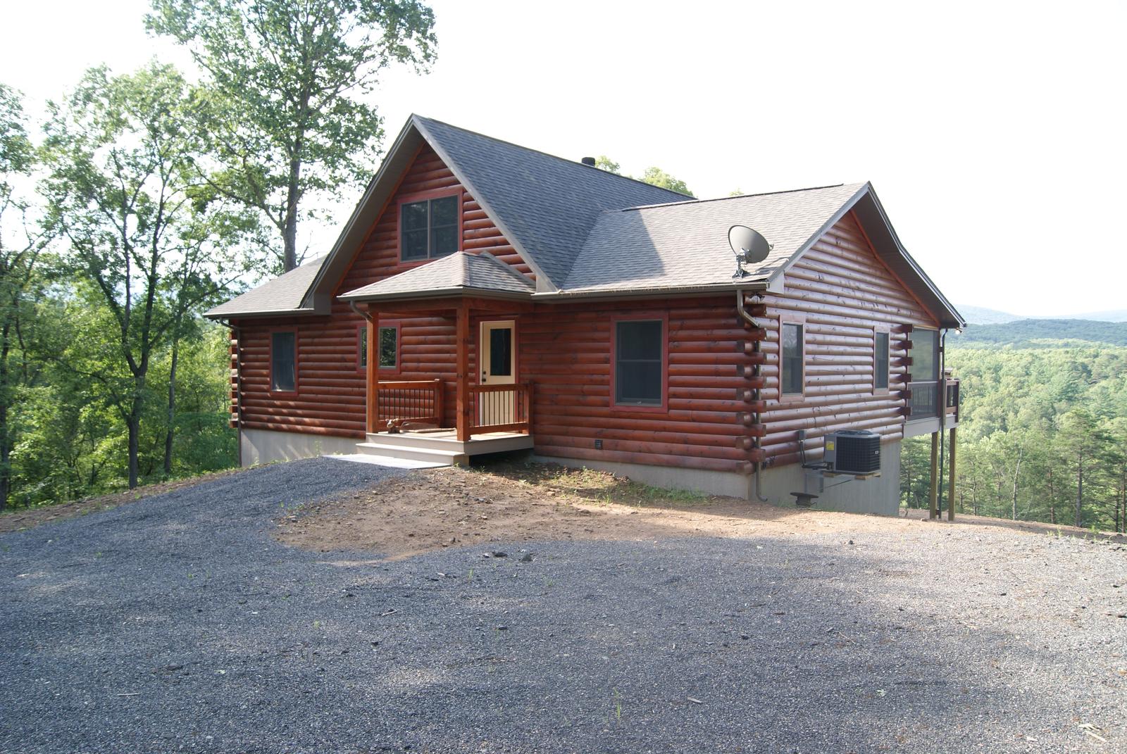 The home from the gravel drive, roof dormer above and a covered entry at the near end