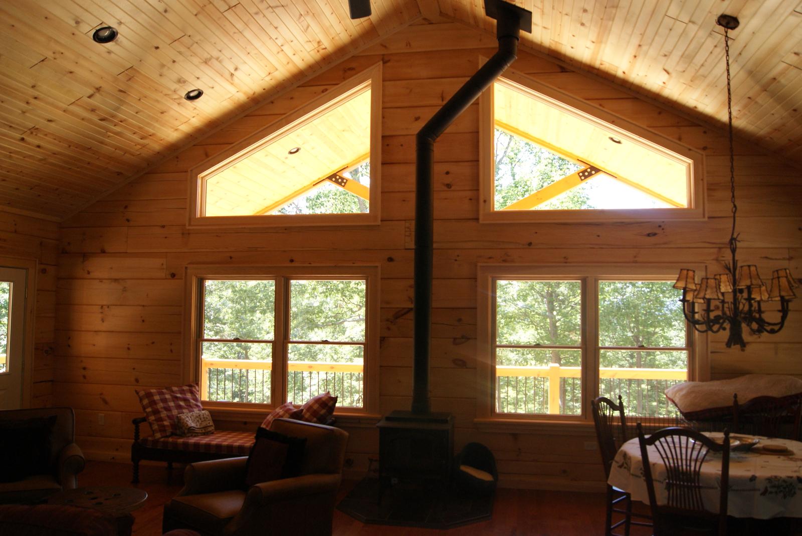 The gable windows and the room below them, the porch and its railing showing through the glass