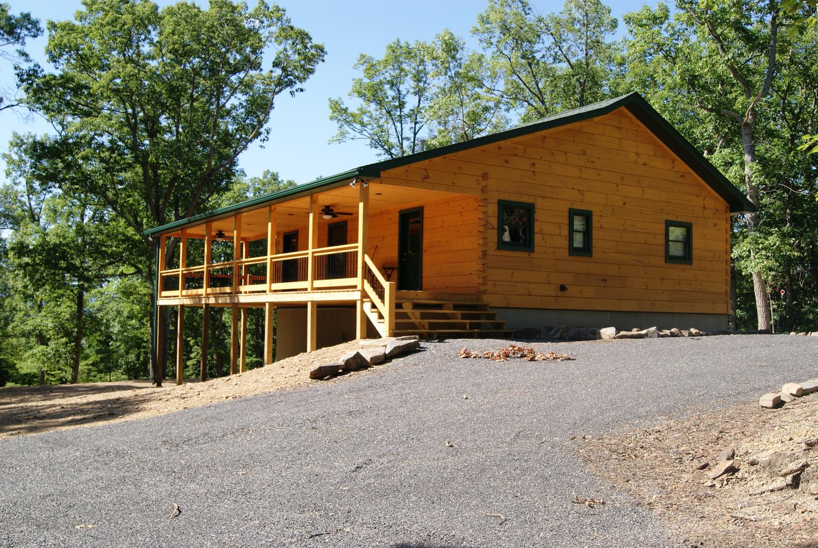 The home from the gravel drive, porch on the near side and a plain gable end beyond