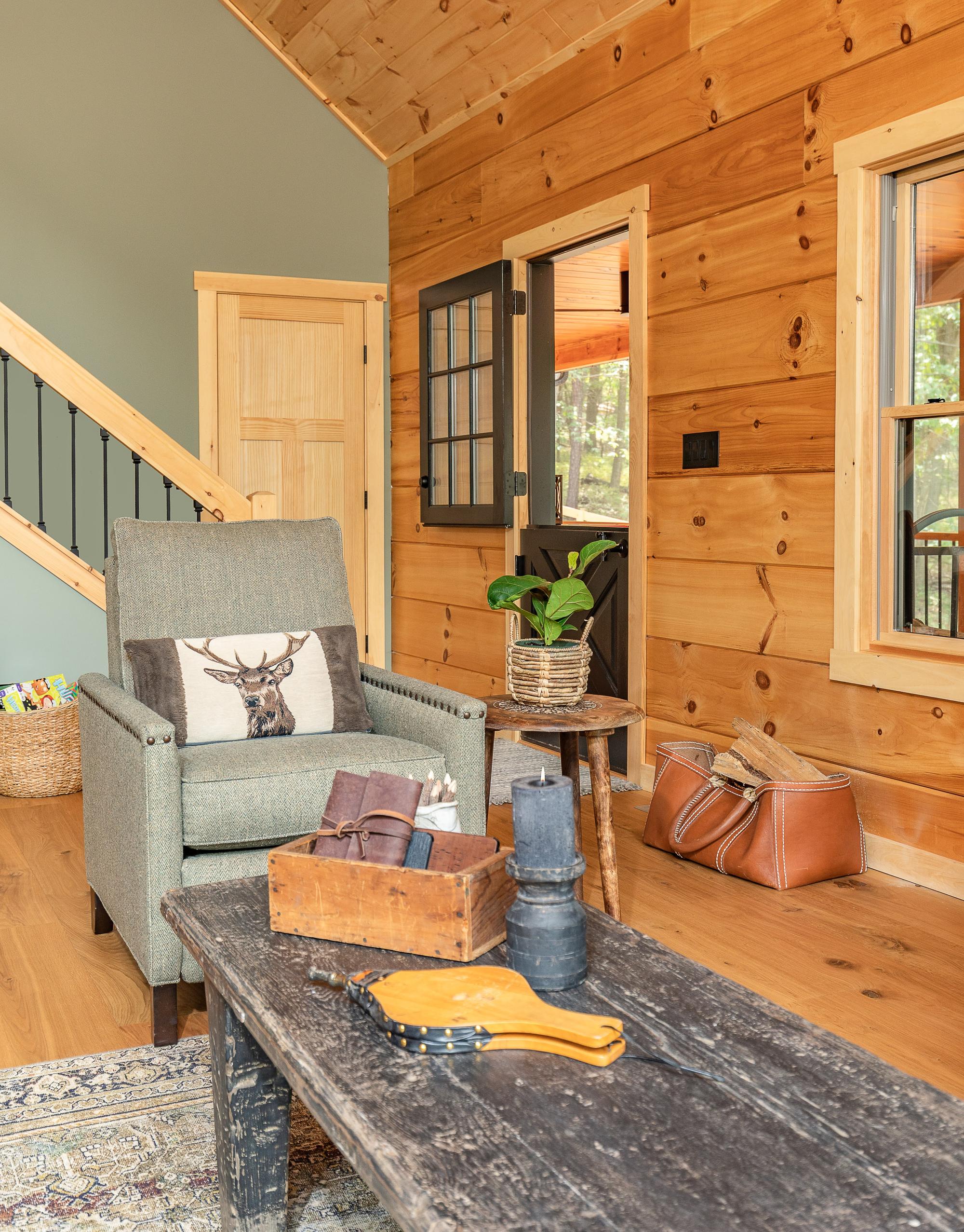 Entry hall with a split dutch door, an armchair and a leather firewood carrier