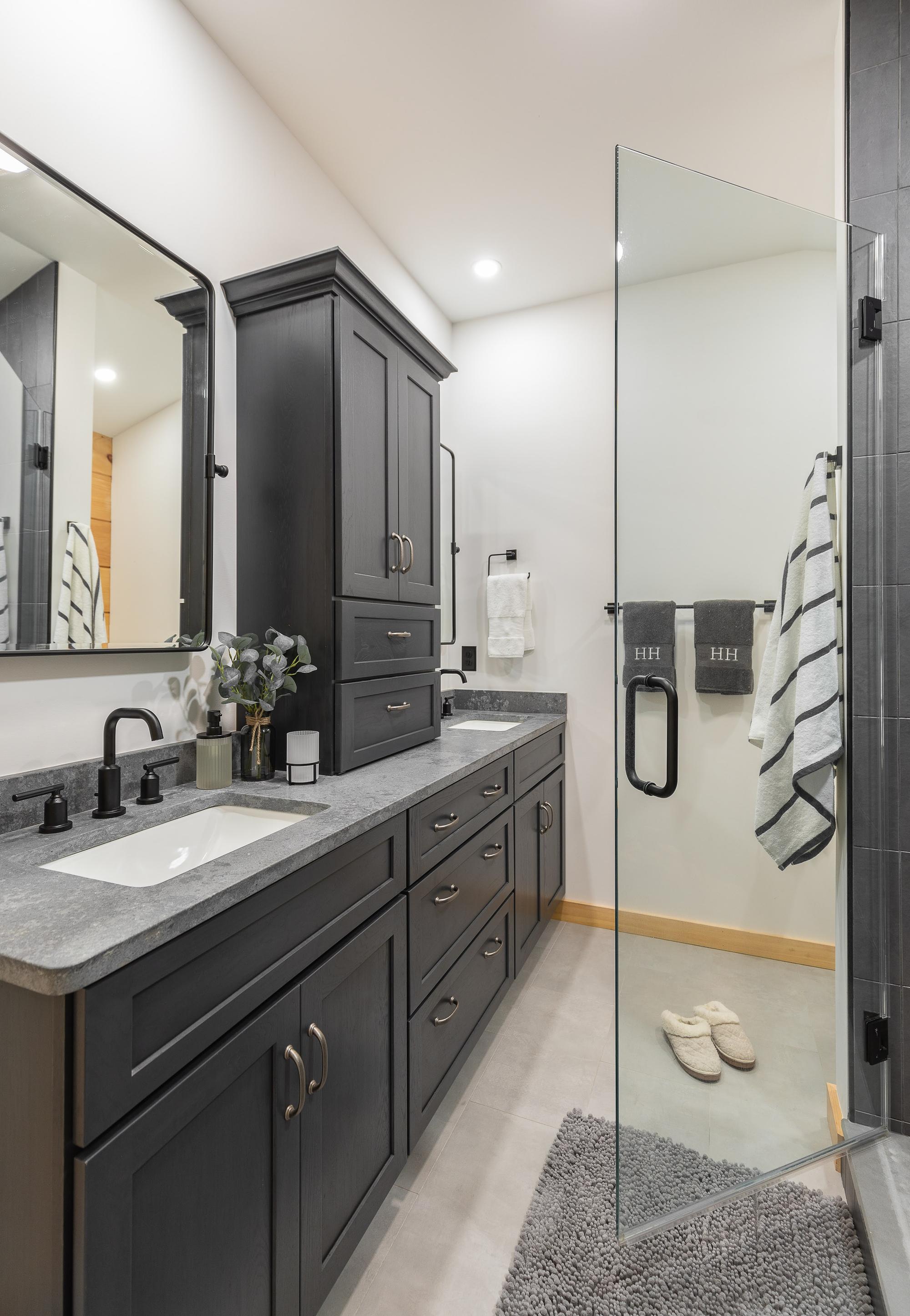 Main bathroom with a double vanity and a glass shower stall
