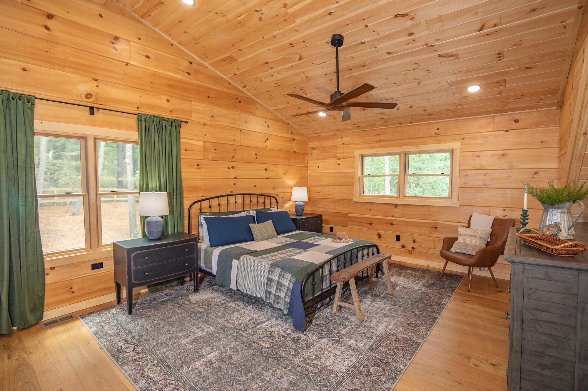 The main bedroom from the opposite corner, showing its windows and dresser
