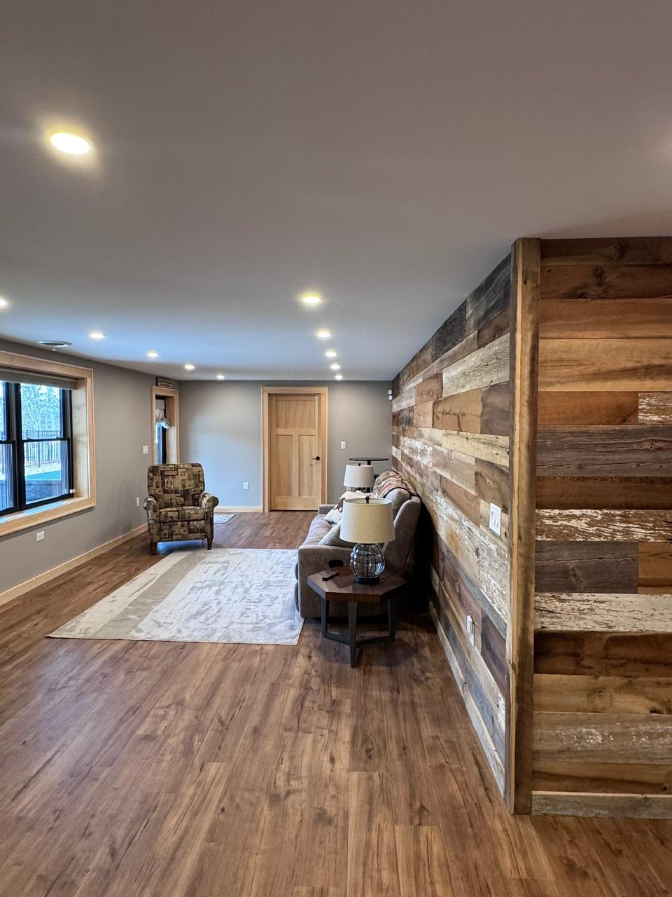 The lower lounge seen down its length, the barnwood wall running the full height on the right
