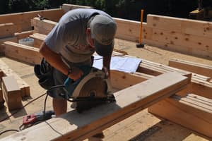 A circular saw cutting through a square-cut log on the deck, with the notched corners of the first wall rows all around.