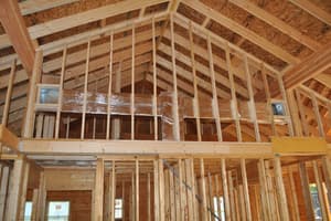 Interior framing under the cathedral ceiling, a loft opening and stud walls dividing up the log shell.