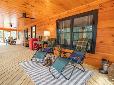 Covered porch with reclining loungers, folded throws and a ceiling fan