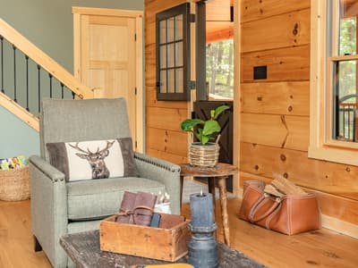 Entry hall with a split dutch door, an armchair and a leather firewood carrier