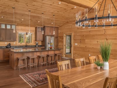 Kitchen with cherry cabinets, granite counters and a bar with wooden stools, the dining table alongside