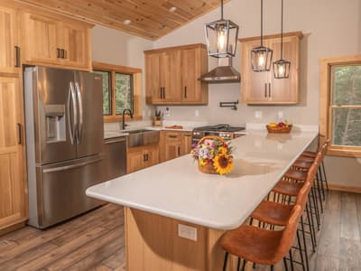 The kitchen along its length, showing the full quartz peninsula and the range wall beyond