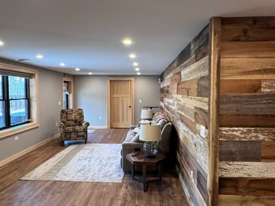 The lower lounge seen down its length, the barnwood wall running the full height on the right