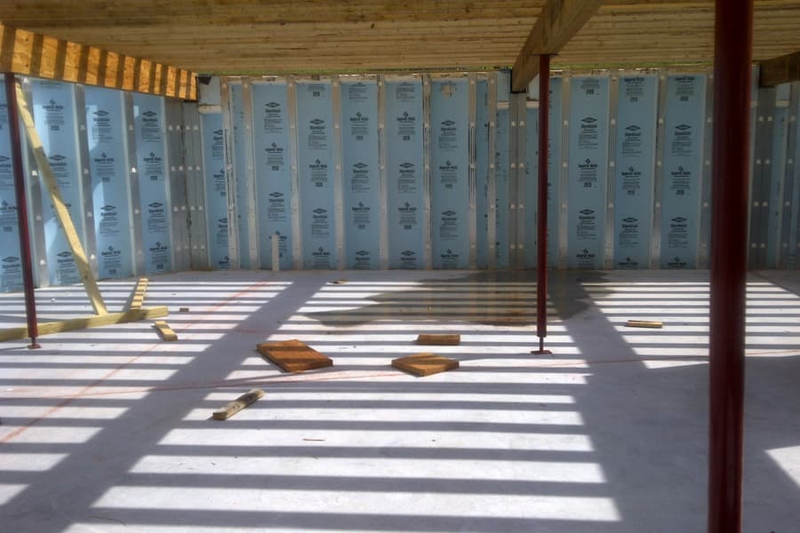 The basement from inside, insulated foundation panels on every wall and steel columns carrying the floor beams overhead